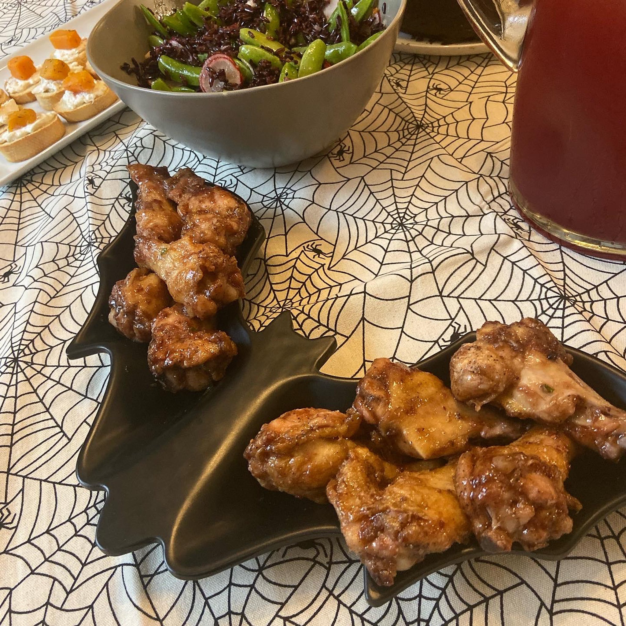 This is a bat-shaped plate filled with saucy chicken wings.