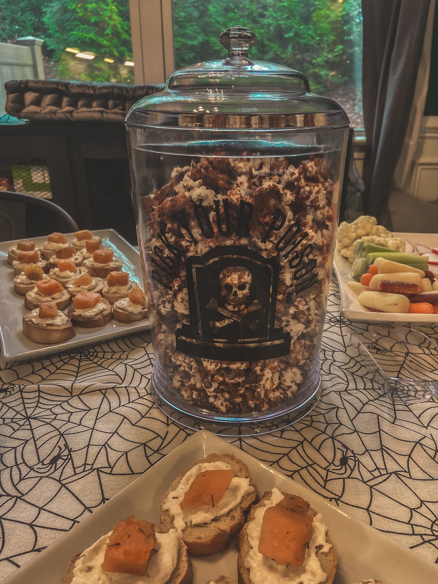 This is a plastic container that says "Pick your Poison" and is filled with caramel corn.