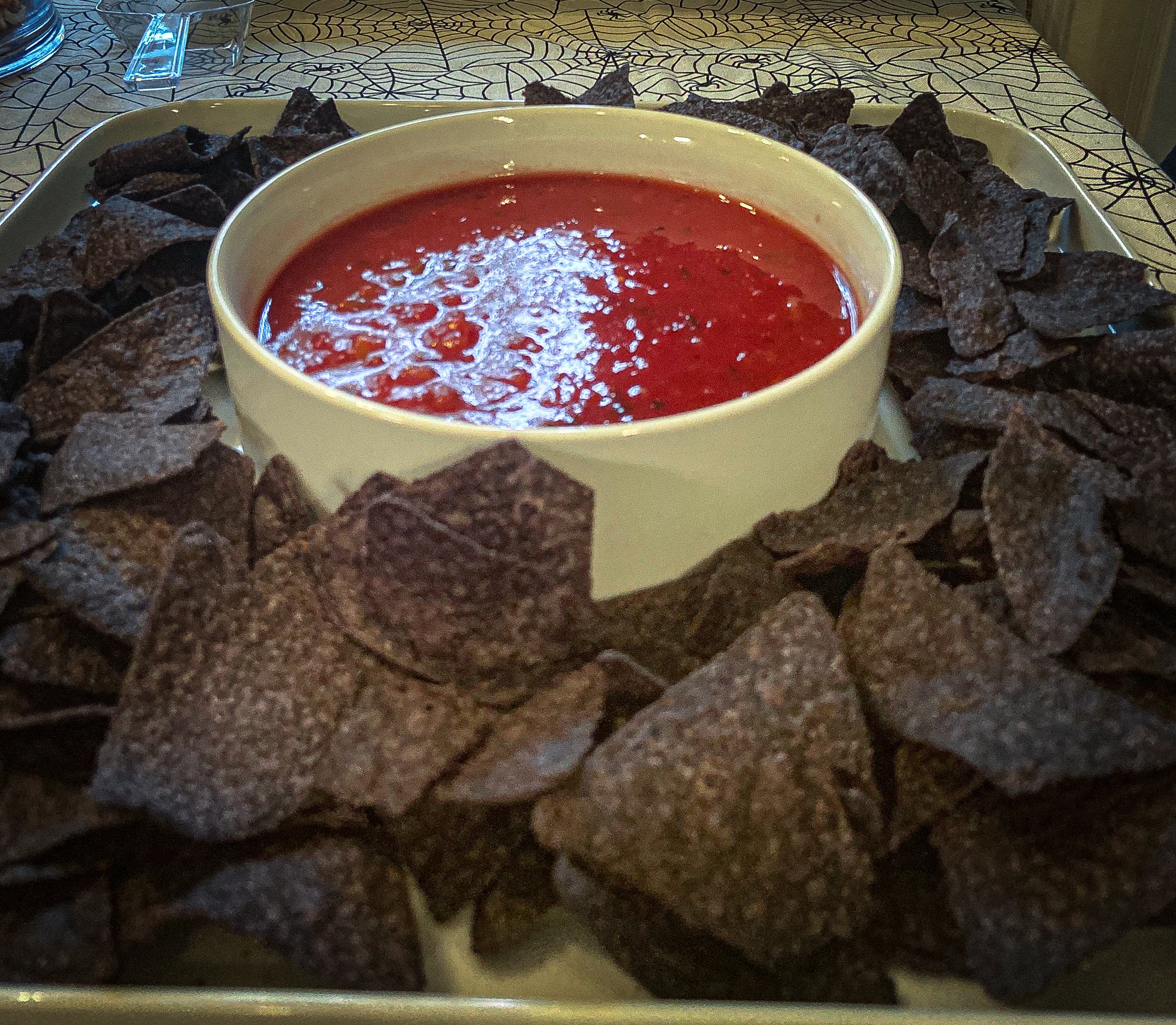 This is a plate of blue corn chips and salsa.
